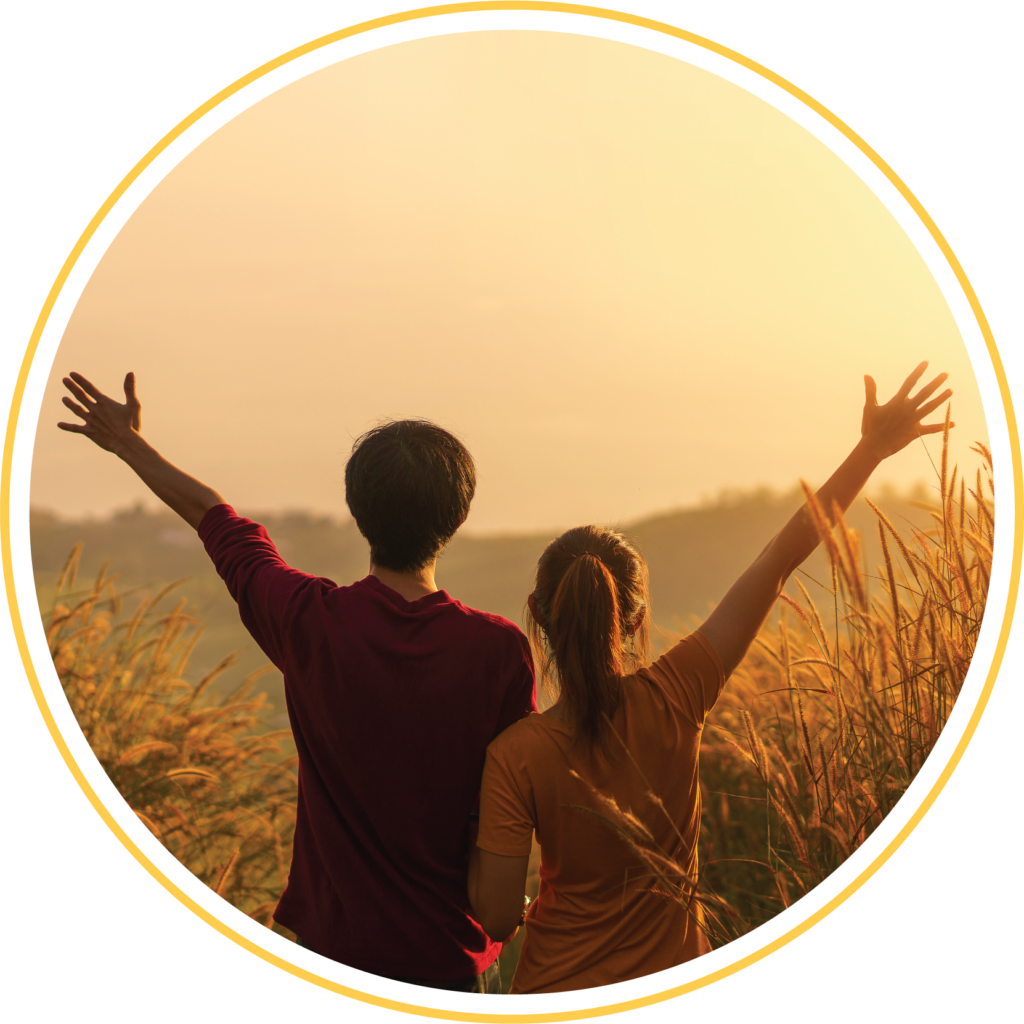 Two friends with hands up during sunrise