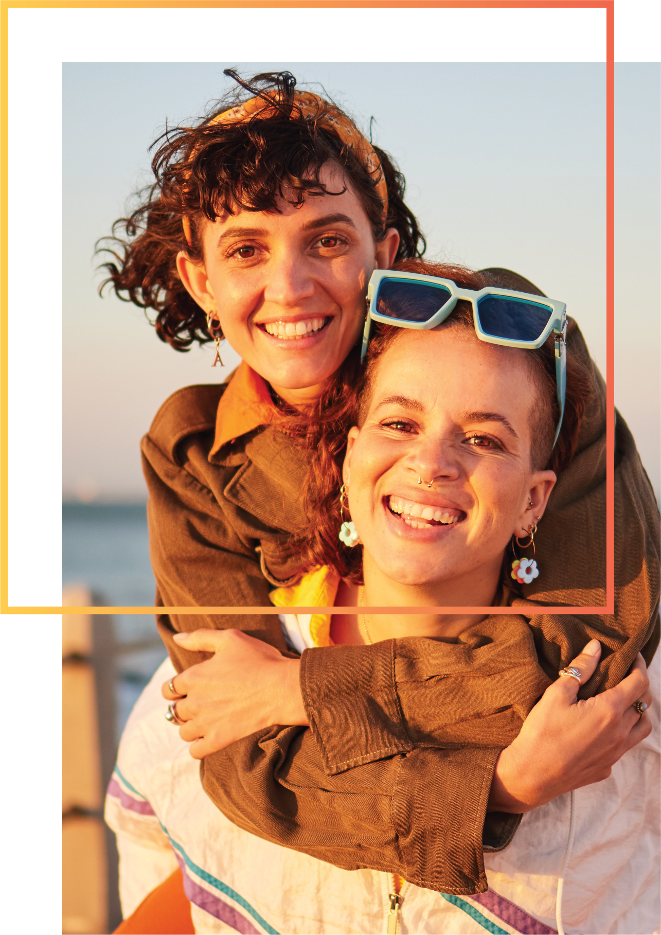 Two women happy by ocean in sun