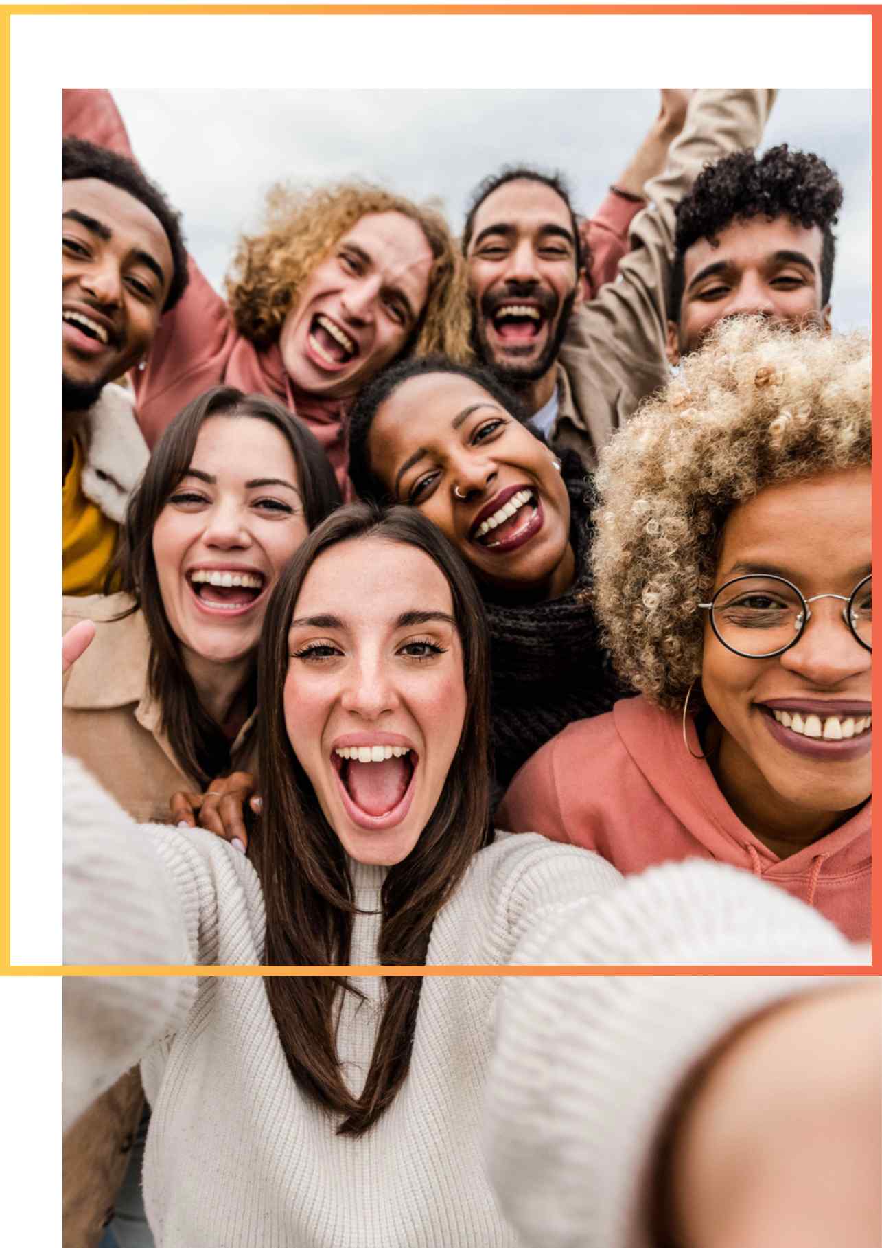 A group of eight diverse friends takes a joyful selfie outdoors. They are smiling and laughing, embodying a sense of happiness and unity.