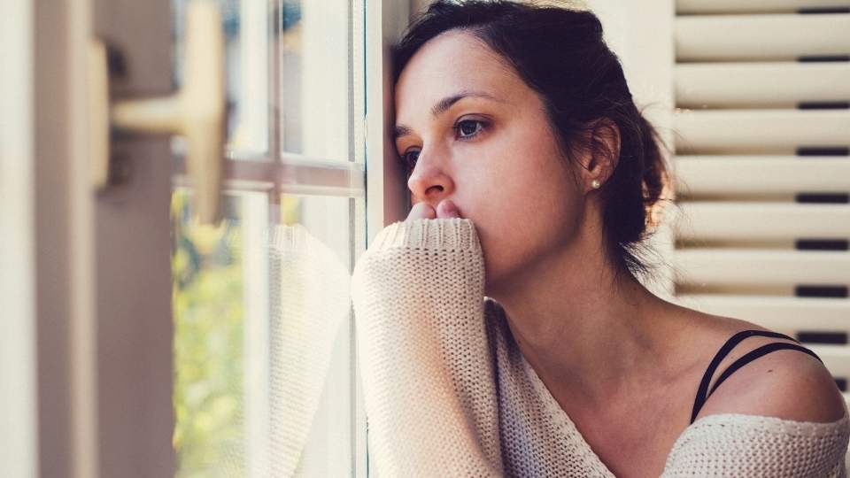 Can ADHD Cause Depression and Anxiety? A woman deals with depression while looking out a window