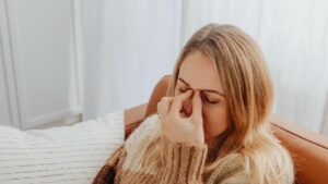 Alcohol Poisoning Symptoms When Drinking Becomes a Medical Emergency hero image of woman with a headache.