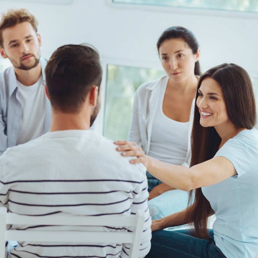 Man being comforted during group therapy