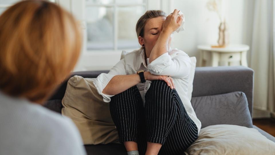 How Long Does Cocaine Stay in Your System a woman talks during therapy about different treatments for addiction.