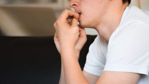 Long-Term Effects of Heroin Use on the Brain and Body hero image of a man biting his fingernails.
