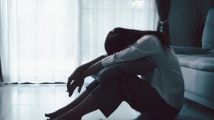 how to know if i'm depressed hero image of a woman with her head down.