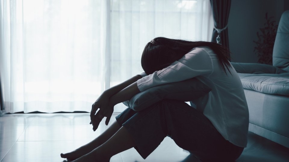 how to know if i'm depressed hero image of a woman with her head down.